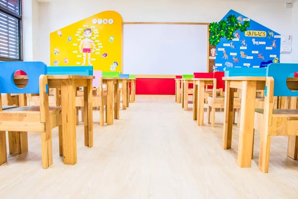 Schreibtische, Stühle und Whiteboard im Klassenzimmer des Kindergartens. — Stockfoto