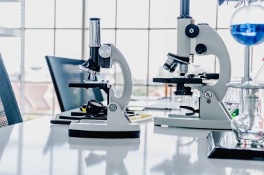 Bilimsel laboratuvarlarda dizüstü bilgisayarlar, akıllı telefonlar, mikroskoplar, deney tüpleri ve bilimsel laboratuvar ekipmanları..