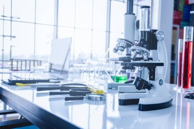 Bilimsel laboratuvarlarda dizüstü bilgisayarlar, akıllı telefonlar, mikroskoplar, deney tüpleri ve bilimsel laboratuvar ekipmanları..
