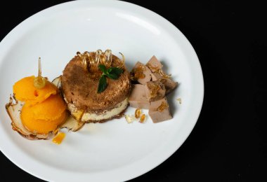 Karamelli tatlı, mangolu dondurma, tiramisu ve siyah arka planda beyaz tabakta çikolatalı mus.