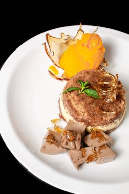 Karamelli tatlı, mangolu dondurma, tiramisu ve siyah arka planda beyaz tabakta çikolatalı mus.