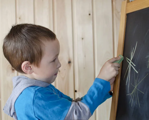 Маленький Мальчик Рисует Звезды Доске Карандашом Фон Натурального Дерева — стоковое фото