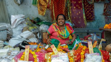 Hindistan 'daki Rath Yatra festivali vesilesiyle sokakta oturan bir kadın çiçek çelengi satıyor. Delhi, Hindistan.