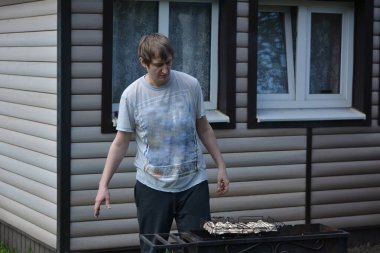 Babam ızgarada mantar barbeküsü hazırlıyor. Dağ evinin temiz havasında tek başına.