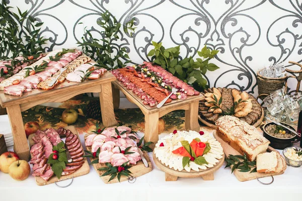 Parti et servis masası. Düğün dekoratif jambon dilimleri. Çeşitli et atıştırmalıkları arka planı. Salam dilimleri, sosis parçaları ve seramik kavanozda yağlı domuz yağı. Lezzetli yemek geçmişi.