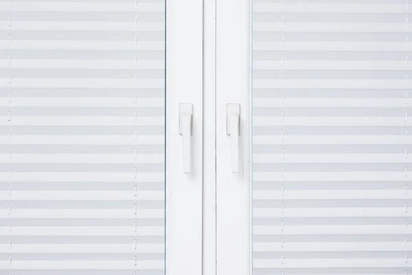 White plastic window home indoor. Empty copy space pleated blinds texture. Plastic window handle striped curtain. PVC interiors closed window frame.