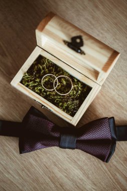 Alyanslar ve altın yüzük ahşap masada.