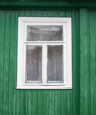 Yeşil boyalı ve küçük pencereli eski ahşap ev