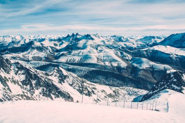 Fransız Alpleri kış manzarası. Yüksek kar ortamı. Dağ beyaz karla kaplı. Güneşli kış panoramik manzarası. Turizm beldesinde kayak ve snowboard yamacı.