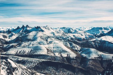Fransız Alpleri kış manzarası. Yüksek kar ortamı. Dağ beyaz karla kaplı. Güneşli kış panoramik manzarası. Turizm beldesinde kayak ve snowboard yamacı.