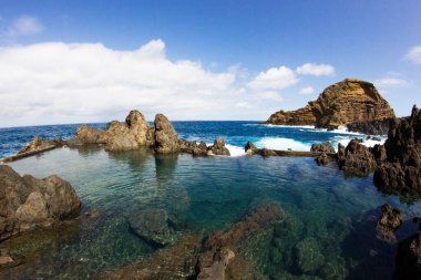 Lav Madeira havuzları. Porto Moniz doğal yüzme havuzları. Lav kayası güzel Portekiz manzarası. Güneşli bir gün Atlantik okyanusu berrak şeffaf su.