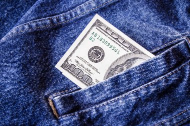 Cep harçlığı geçmişi. Kot pantolonla 100 dolarlık banknot. Tek banknot kot arka planı. Moda para dokusu.