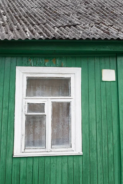 有绿色油漆和小窗户的旧木制房子 — 图库照片