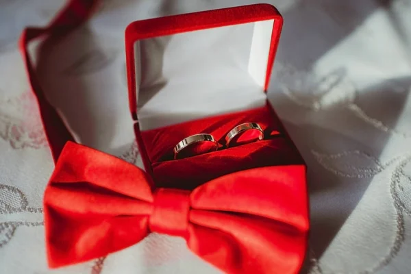 結婚指輪とテーブルの上の赤い弓 — ストック写真