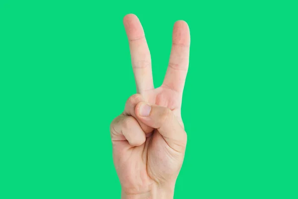 Männerhand Zeigt Friedenszeichen Mit Den Fingern Auf Grünem Hintergrund — Stockfoto