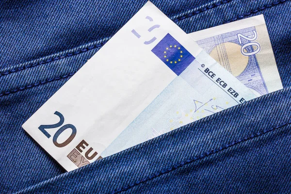 Pocket money background. Twenty euro bill in blue jeans. Single banknote denim backdrop. Fashion money texture.