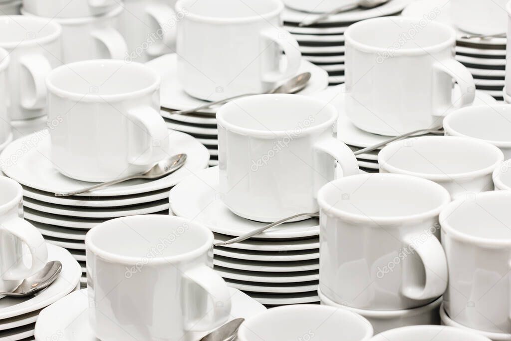 Catering company coffee table. Pile of white ceramic cups background. Small coffee mugs texture.