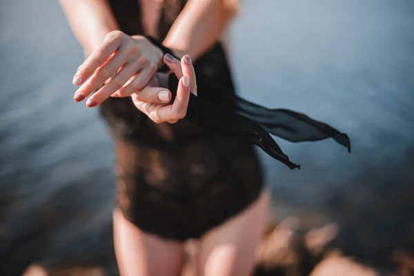 Uzun saçlı çıplak bir kız, zayıf bir vücut ve büyük doğal göğüsler, güneşli bir yaz gününde çıplak bir şekilde ormanda yürüyüş için poz veriyor.