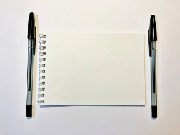 Papier carnet ouvert avec stylo noir sur bureau blanc, espace de copie — Photo