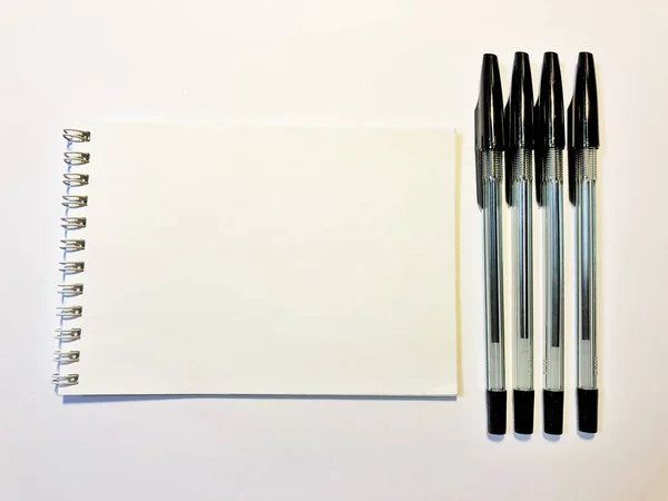 Papier carnet ouvert avec stylo noir sur bureau blanc, espace de copie — Photo