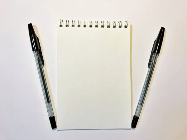 Opened notebook paper with black pen on white desk, copy space — Stockfoto