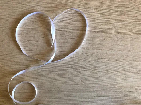 Hjärta gjord av vitt band på en trä bakgrund — Stockfoto