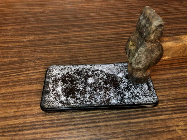 Telefon komórkowy z tłuczonym szkłem na ciemnym drewnianym tle — Zdjęcie stockowe