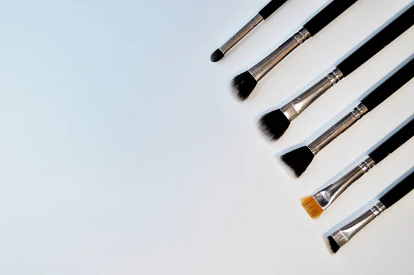 Escovas para maquiagem deitado sobre fundo branco — Fotografia de Stock