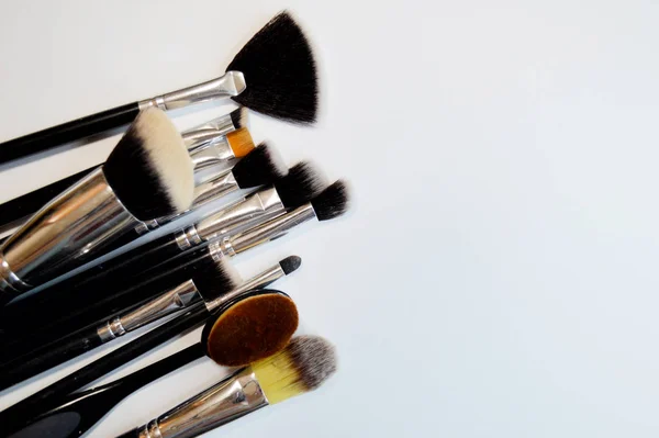 Pinsel für Make-up liegen auf weißem Hintergrund — Stockfoto