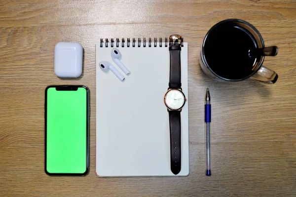 Telefon, sluchátka, hodinky, notebook, káva a pero na dřevěném pozadí — Stock fotografie