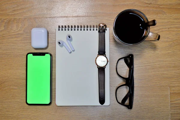 Teléfono, Auriculares, Reloj de pulsera, portátil, café, vasos sobre fondo de madera —  Fotos de Stock