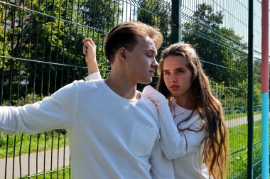 Genç bir kız ve genç bir adam oyun sahasında aynı kıyafetleri giymiş..