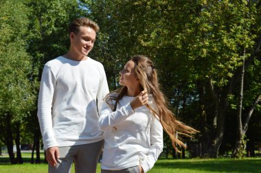 Genç bir kız ve genç bir adam su kenarındaki ahşap iskelede