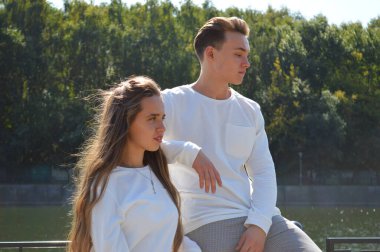 Suya yakın bir köprüde genç bir kız ve aynı kıyafetleri giyen genç bir adam..