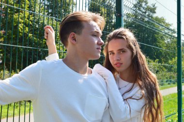 Genç bir kız ve genç bir adam oyun sahasında aynı kıyafetleri giymiş..