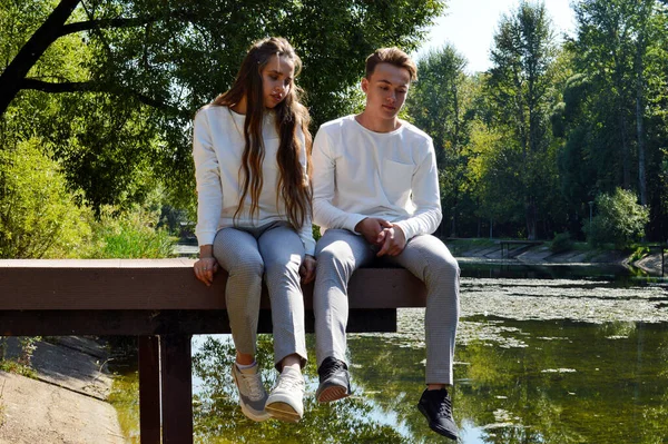 물 근처에 있는 나무배 위에 있는 한 젊은 소녀와 젊은 남자 — 스톡 사진