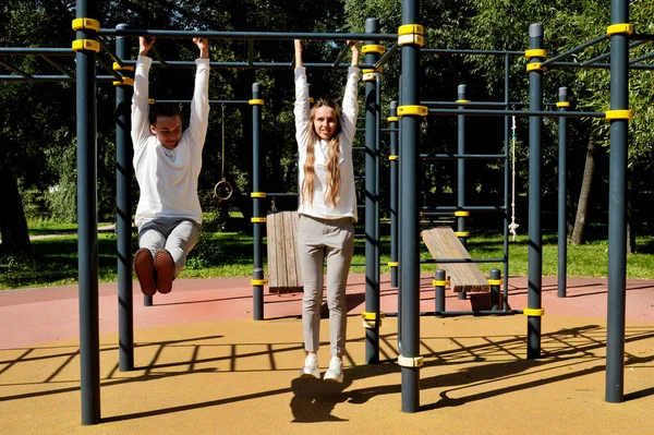 Genç bir kız ve genç bir adam oyun sahasında aynı kıyafetleri giymiş..