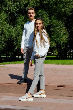 Genç bir kız ve genç bir adam su kenarındaki ahşap iskelede