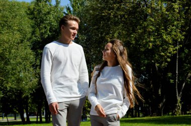 Genç bir kız ve genç bir adam su kenarındaki ahşap iskelede