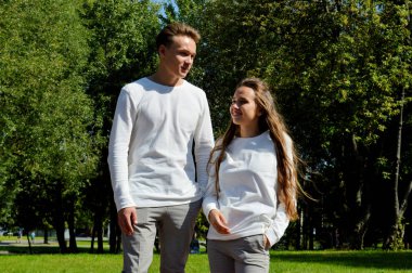 Genç bir kız ve genç bir adam su kenarındaki ahşap iskelede