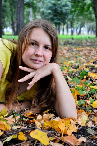 Woman with dark hair in a yellow T-shirt with yellow foliage