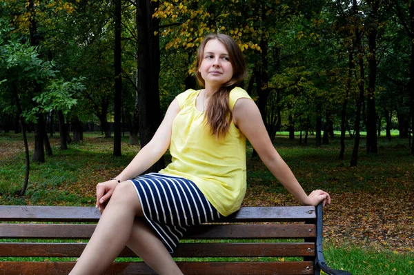 Frau Mit Dunklen Haaren Sitzt Gelbem Shirt Auf Holzbank — Stockfoto