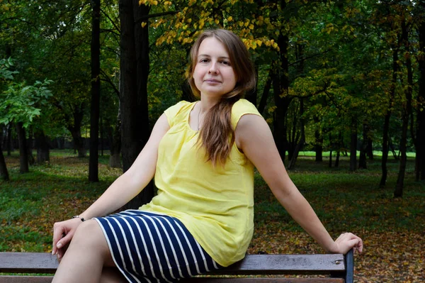 Frau Mit Dunklen Haaren Sitzt Gelbem Shirt Auf Holzbank — Stockfoto