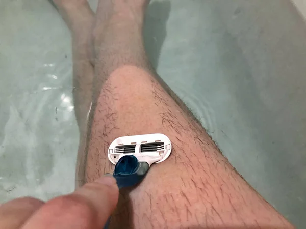 Woman touching her woolly hairy leds. Razor shaves his legs. — Stock Image Woman touching her woolly hairy leds. Razor shaves his legs. Stock Photo