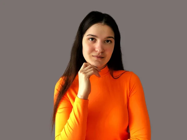 Młoda Piękna Dziewczyna Ciemnymi Włosami Jasnopomarańczowym Swetrze Szarym Tle — Zdjęcie stockowe