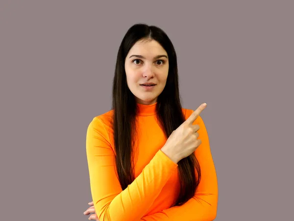 一个年轻漂亮的姑娘 黑头发 穿着鲜艳的橙色毛衣 灰色背景 — 图库照片