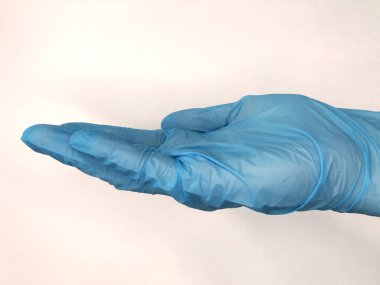 Beyaz arka planda hapları olan mavi eldiven.