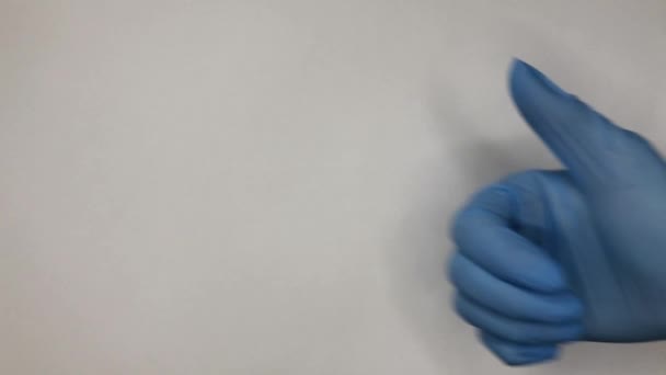 手给大拇指向上伸出白色背景 手拿起在白色背景上隔离的手势 穿着蓝色手套 — 图库视频影像