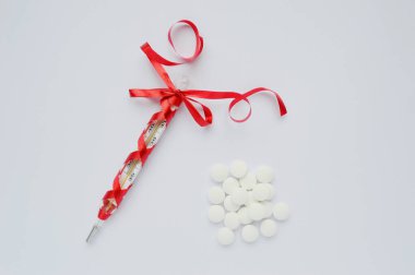 Cam tıbbi termometre ve izole edilmiş arka planda kırmızı bir fiyonk. Dünya Sağlık Günü sindirimi