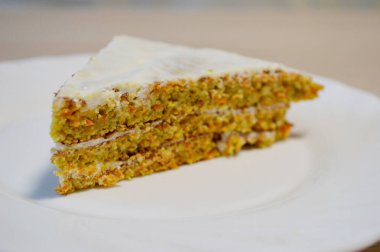 Beyaz tabakta ev yapımı havuçlu kek. Çok sığ bir tarla..